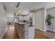 Bright kitchen with stone-accented island, stainless steel appliances, and hardwood floors at 3323 W Hayward Pl, Denver, CO 80211