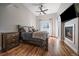 Cozy bedroom with hardwood floors, a fireplace, tv and a ceiling fan at 3323 W Hayward Pl, Denver, CO 80211
