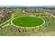 Community aerial view featuring a large grassy circular field, playground, park, and numerous homes at 10185 Isle St, Parker, CO 80134