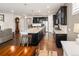Open-concept kitchen with dark cabinets, a large island, stainless appliances, and hardwood floors at 10185 Isle St, Parker, CO 80134