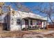 View of the house with bright red front doors, covered porch and landscaping with leafless tree branches at 723 W 5Th Ave, Denver, CO 80204