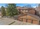 Exterior view of home with attached three-car garage and mature trees at 9411 W 89Th Cir, Westminster, CO 80021
