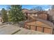 Townhome exterior with three-car garage, wooden siding, and partial view of the balcony in a residential neighborhood at 9411 W 89Th Cir, Westminster, CO 80021