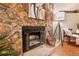 Stone fireplace and hearth with decor and logs basket at 9411 W 89Th Cir, Westminster, CO 80021