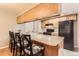 Functional kitchen featuring a breakfast bar, black appliances, and wood cabinetry at 9411 W 89Th Cir, Westminster, CO 80021