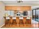Kitchen featuring breakfast bar with white stools, and wood cabinetry at 9411 W 89Th Cir, Westminster, CO 80021