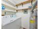 A functional laundry room with a washing machine, dryer, shelving, and utilitarian details at 9411 W 89Th Cir, Westminster, CO 80021