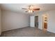 Large bedroom featuring a ceiling fan, carpet floors, and bathroom access at 19618 Rosewood Ct, Parker, CO 80138