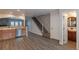 Modern kitchen area flowing into the stairwell with stone accents and a half bathroom nearby at 19618 Rosewood Ct, Parker, CO 80138