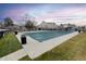 Community pool with a green cover, surrounded by lush landscaping, and neighborhood townhomes at 19618 Rosewood Ct, Parker, CO 80138