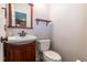 Charming powder room with wood vanity, stylish faucet, and convenient wall shelf at 19618 Rosewood Ct, Parker, CO 80138