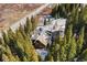 An aerial view of home surrounded by beautiful, tall evergreen trees with road nearby at 50 Cooney Ct, Breckenridge, CO 80424