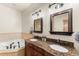Bathroom featuring granite counters, double sinks, custom wood cabinets and a jacuzzi tub at 50 Cooney Ct, Breckenridge, CO 80424