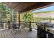 Relaxing deck with outdoor seating and grill, surrounded by scenic mountain views and lush trees at 50 Cooney Ct, Breckenridge, CO 80424