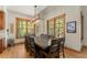 Bright dining room with wooden table and antler chandelier, framed by large windows overlooking lush greenery at 50 Cooney Ct, Breckenridge, CO 80424