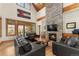 Cozy living room featuring a stone fireplace, hardwood floors, and large windows with stunning mountain views at 50 Cooney Ct, Breckenridge, CO 80424