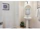 Small powder room with pedestal sink and oval mirror at 10251 Rifle St, Commerce City, CO 80022