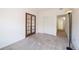 This bedroom features neutral carpet, white walls, stylish french doors, and a spacious closet at 9973 E Carolina Cir # 104, Aurora, CO 80247