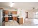 Kitchen with modern appliances and warm wood cabinets adjacent to a living space with sliding door access at 9973 E Carolina Cir # 104, Aurora, CO 80247