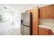 Modern kitchen featuring a stainless steel refrigerator, warm wood cabinets and tile flooring at 9973 E Carolina Cir # 104, Aurora, CO 80247