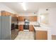 Well-lit kitchen with stainless steel appliances, light wood cabinets, and tile flooring at 9973 E Carolina Cir # 104, Aurora, CO 80247