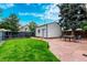 Landscaped backyard featuring a stone patio with a dining table and a detached garage at 2745 N Saint Paul St, Denver, CO 80205