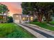 Charming brick home featuring a well-manicured lawn and driveway with a garage, all bathed in warm sunset light at 2745 N Saint Paul St, Denver, CO 80205