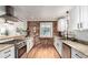 Bright kitchen featuring white cabinets, granite countertops, stainless steel appliances, and a rustic brick accent wall at 2745 N Saint Paul St, Denver, CO 80205