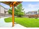Serene backyard view featuring lush green grass, a patio and partial shade coverage creating an inviting outdoor oasis at 10235 Rustic Redwood Ln, Highlands Ranch, CO 80126