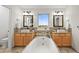 Well-lit bathroom featuring double sinks, a soaking tub, and modern fixtures and finishes at 10235 Rustic Redwood Ln, Highlands Ranch, CO 80126