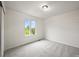 Bright bedroom with large window and neutral carpet and walls at 10235 Rustic Redwood Ln, Highlands Ranch, CO 80126