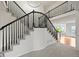 Elegant foyer showcasing a staircase with dark railings, carpeting, and a view into other living spaces at 10235 Rustic Redwood Ln, Highlands Ranch, CO 80126