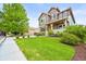 Well-maintained front yard with lush green lawn, garden beds, and a mature tree accenting the property at 10235 Rustic Redwood Ln, Highlands Ranch, CO 80126