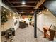 Cozy basement with exposed beams, painted brick, comfortable seating, and stylish decor at 325 E 7Th Ave, Denver, CO 80203