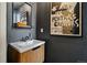 Stylish powder room with a modern vanity, sleek mirror, and vintage-inspired art at 325 E 7Th Ave, Denver, CO 80203