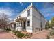 Charming brick townhome with a covered front porch, mature trees, and professional landscaping at 325 E 7Th Ave, Denver, CO 80203