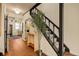 Inviting hallway with hardwood floors leads to the kitchen and staircase with black railing at 325 E 7Th Ave, Denver, CO 80203