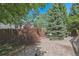 Lush backyard features a mix of mature trees, shrubs, and a gravel area at 6143 E Hinsdale Ave, Centennial, CO 80112