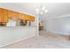 Bright kitchen with wooden cabinets, a breakfast bar, and view into the living room at 6143 E Hinsdale Ave, Centennial, CO 80112
