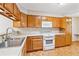 Functional kitchen with wood cabinets, white appliances, and tile backsplash at 6143 E Hinsdale Ave, Centennial, CO 80112