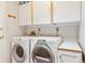 Laundry room features front load washer/dryer and white storage cabinets at 6143 E Hinsdale Ave, Centennial, CO 80112