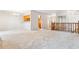 Open-concept living room with wood banister and access to the kitchen and hallway at 6143 E Hinsdale Ave, Centennial, CO 80112