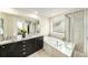 Well-lit bathroom features granite counters, double vanity, a soaking tub and glass enclosed shower at 22870 E Chenango Ave, Aurora, CO 80015