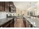 Modern kitchen featuring granite countertops, dark wood cabinets, and stainless steel appliances at 22870 E Chenango Ave, Aurora, CO 80015