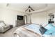 Spacious main bedroom with ceiling fan, tray ceilings, and comfortable armchair at 22870 E Chenango Ave, Aurora, CO 80015