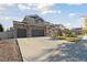 Stunning two-story home with a three-car garage, stone accents, and well-manicured lawn at 385 Poppy View Ln, Erie, CO 80516