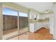 Bright kitchen with white cabinetry and hardwood floors, adjacent to a sliding door to the patio at 6495 E Happy Canyon Rd # 171, Denver, CO 80237