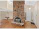 A spacious room features a large brick fireplace, a pendant light and hardwood floors at 6495 E Happy Canyon Rd # 171, Denver, CO 80237