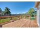 Wooden back deck area with railing, potted plants, and lawn area overlooking privacy fence at 714 Sedge Way, Lafayette, CO 80026