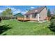 View of home's backyard and wooden back deck with lawn area and privacy fence at 714 Sedge Way, Lafayette, CO 80026